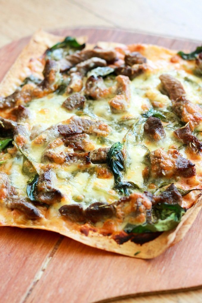 Greek Lamb Pizza on a wooden board.