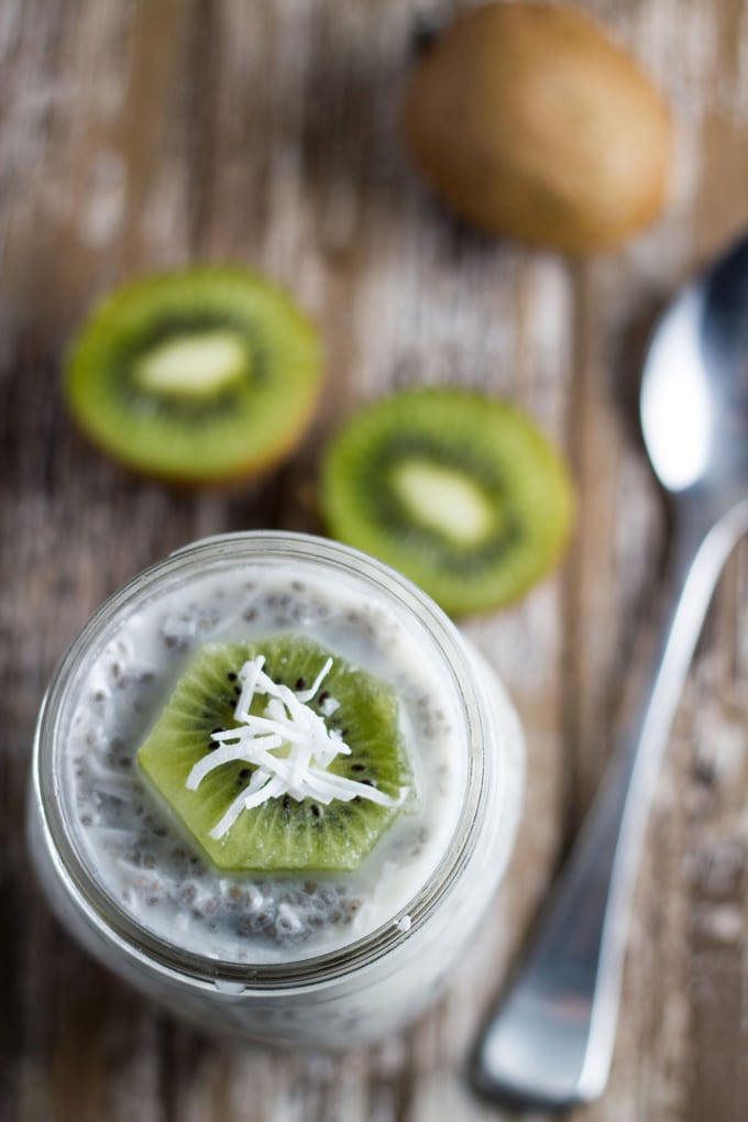 kiwi chia pudding in a mason jar surrounded by kiwi fruit