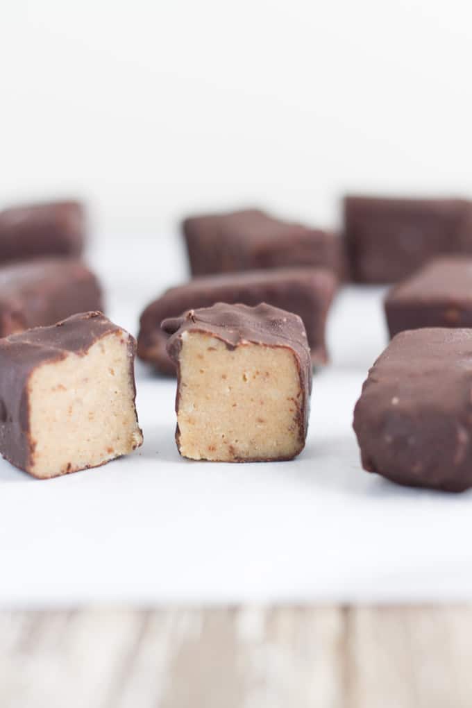 Healthy Chocolate Covered Caramels on baking paper on top of a board.