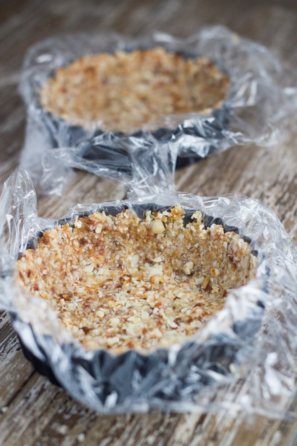 Preparing two tart bases using cling wrap.