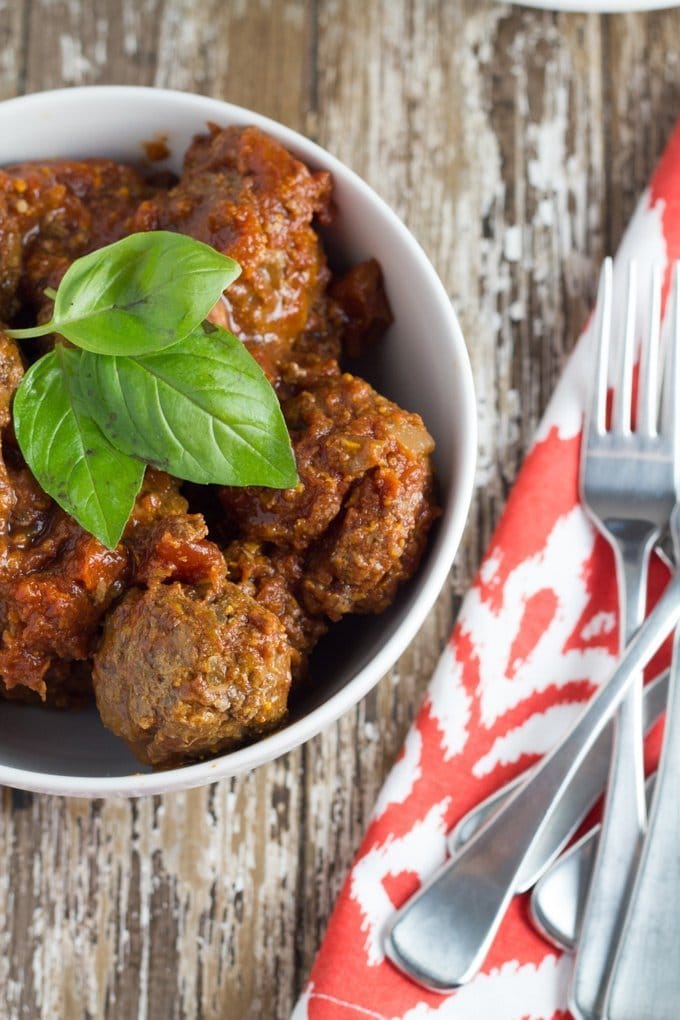 Bowl of gluten free meatballs toppped with fresh basil.