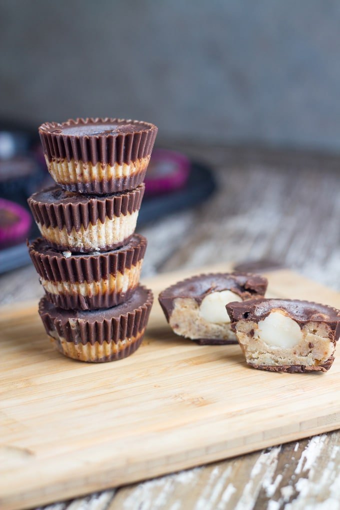 Stack of Caramel Macadamia Chocolate Cups on a board.