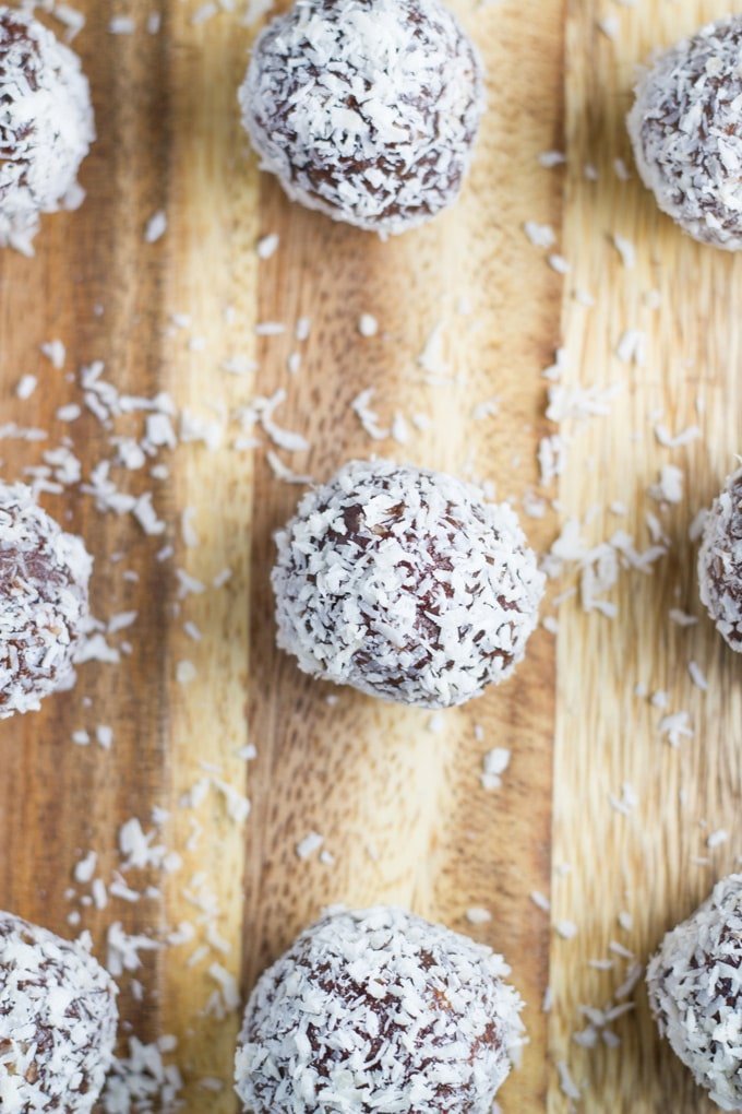 Chocolate orange bliss balls on a wooden board.