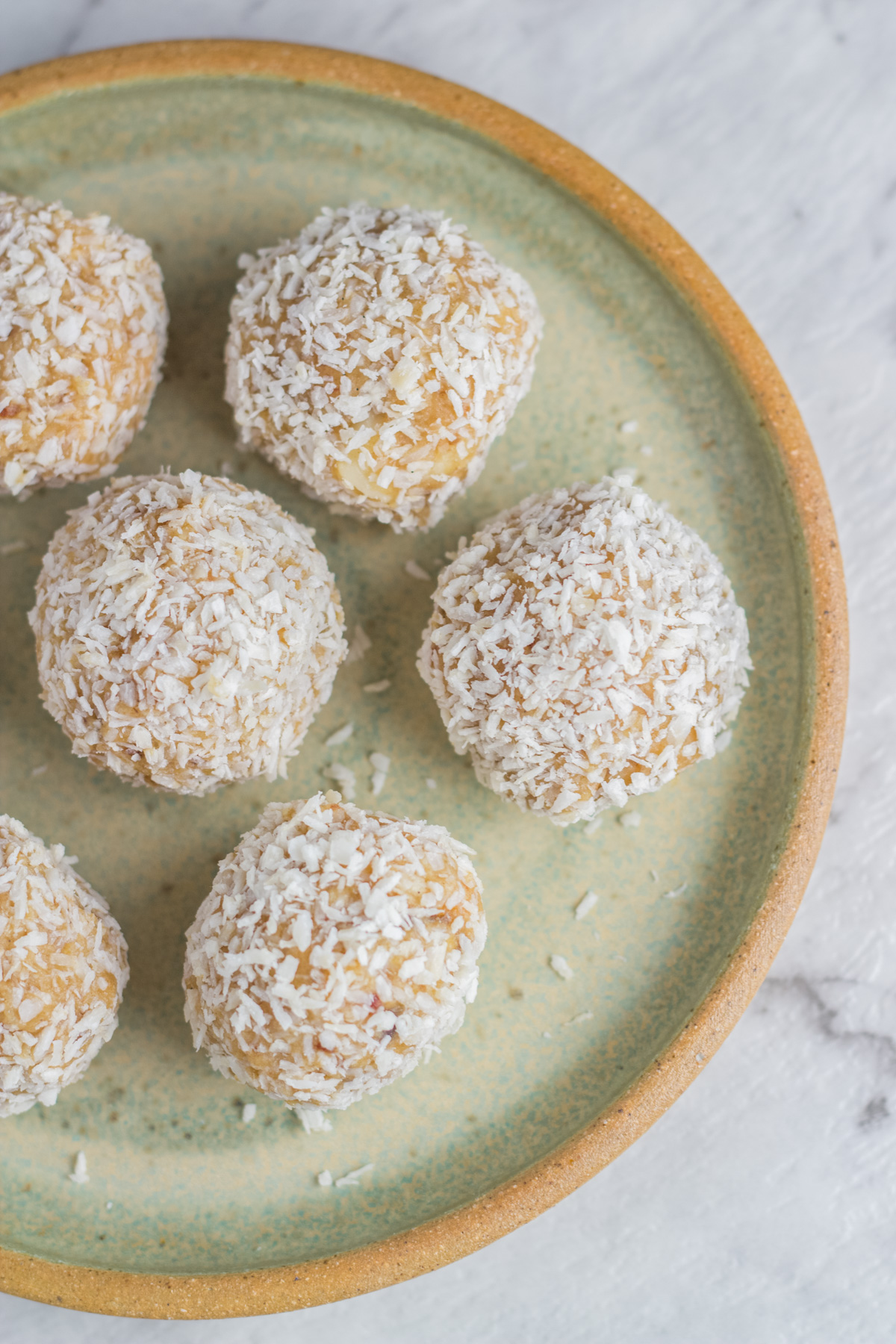 top down view of a plate with raw caramel macadamia bliss balls