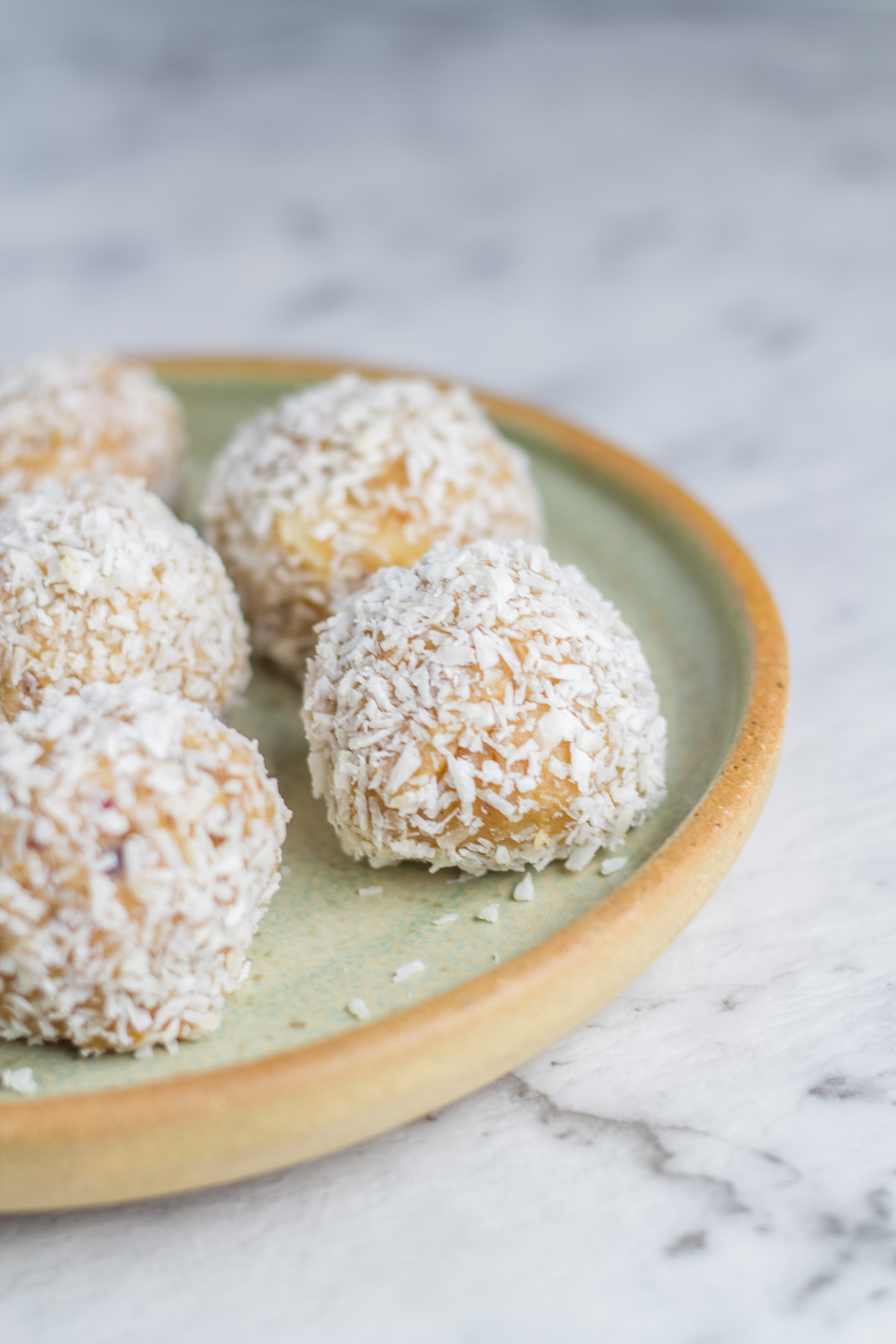 Plate with raw caramel macadamia bliss balls.