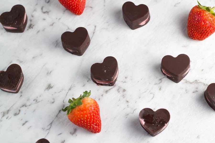 strawberry heart chocolates on a white marble board.