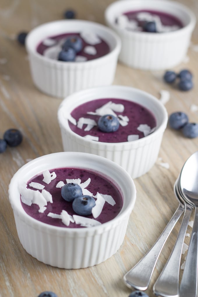 Four ramekins of B=blueberry mousse topped with blueberries and shredded coconut.