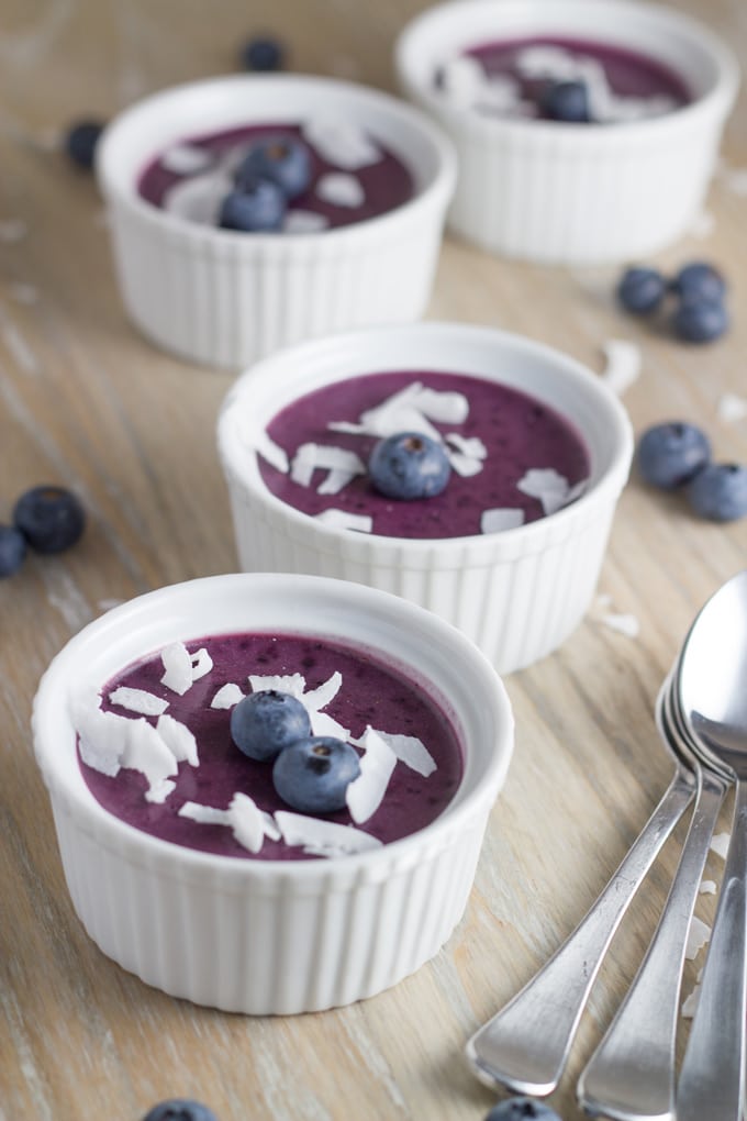 Four ramekins of B=blueberry mousse topped with blueberries and shredded coconut. 