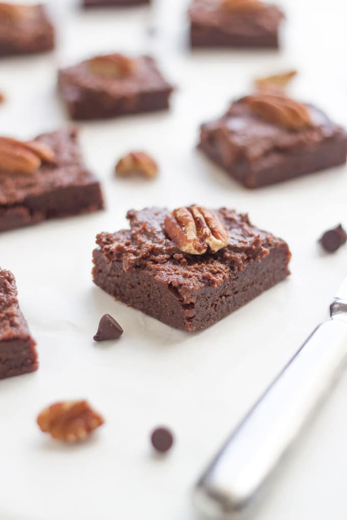 No Bake Brownies on a white background with some chocolate chips and walnuts.