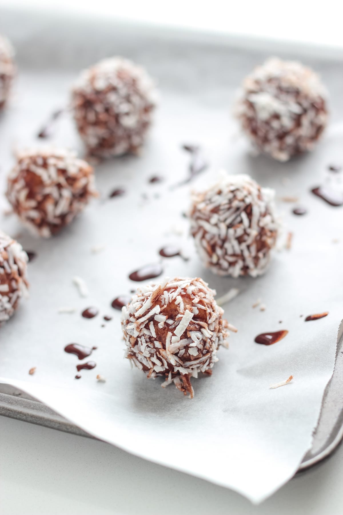 The bliss balls on a baking tray lined with baking paper.