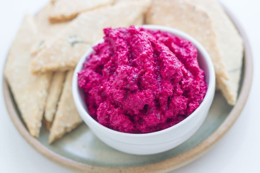 A bowl of dip with crackers. 