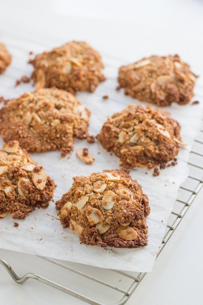 Gluten free Anzac biscuits on baking paper on a baking tray.