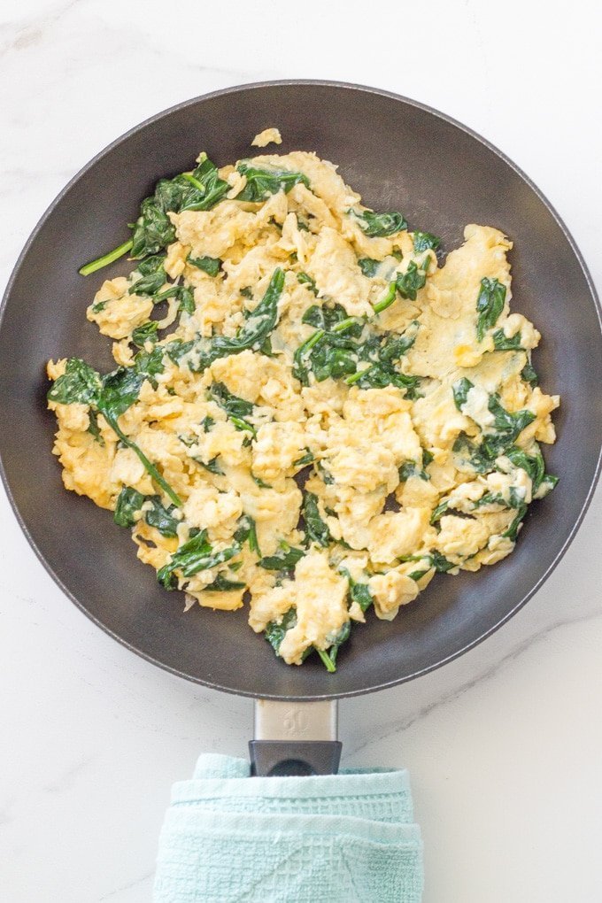 Frypan of spinach scrambled eggs.