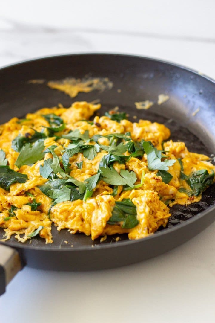 Fry pan with cooked scrambled eggs.