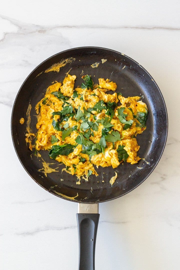 A skillet with cooked turmeric eggs. 