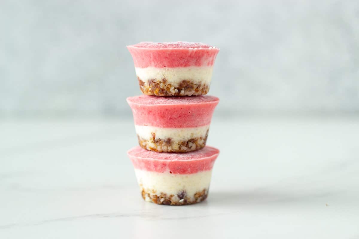 No bake strawberry and lemon cheesecake bites! Consisting of three amazing layers, the macadamia and date base, lemon layer and the strawberry layer on top. These delicious mini raw cheesecakes are super easy to make and have the most amazing flavour.