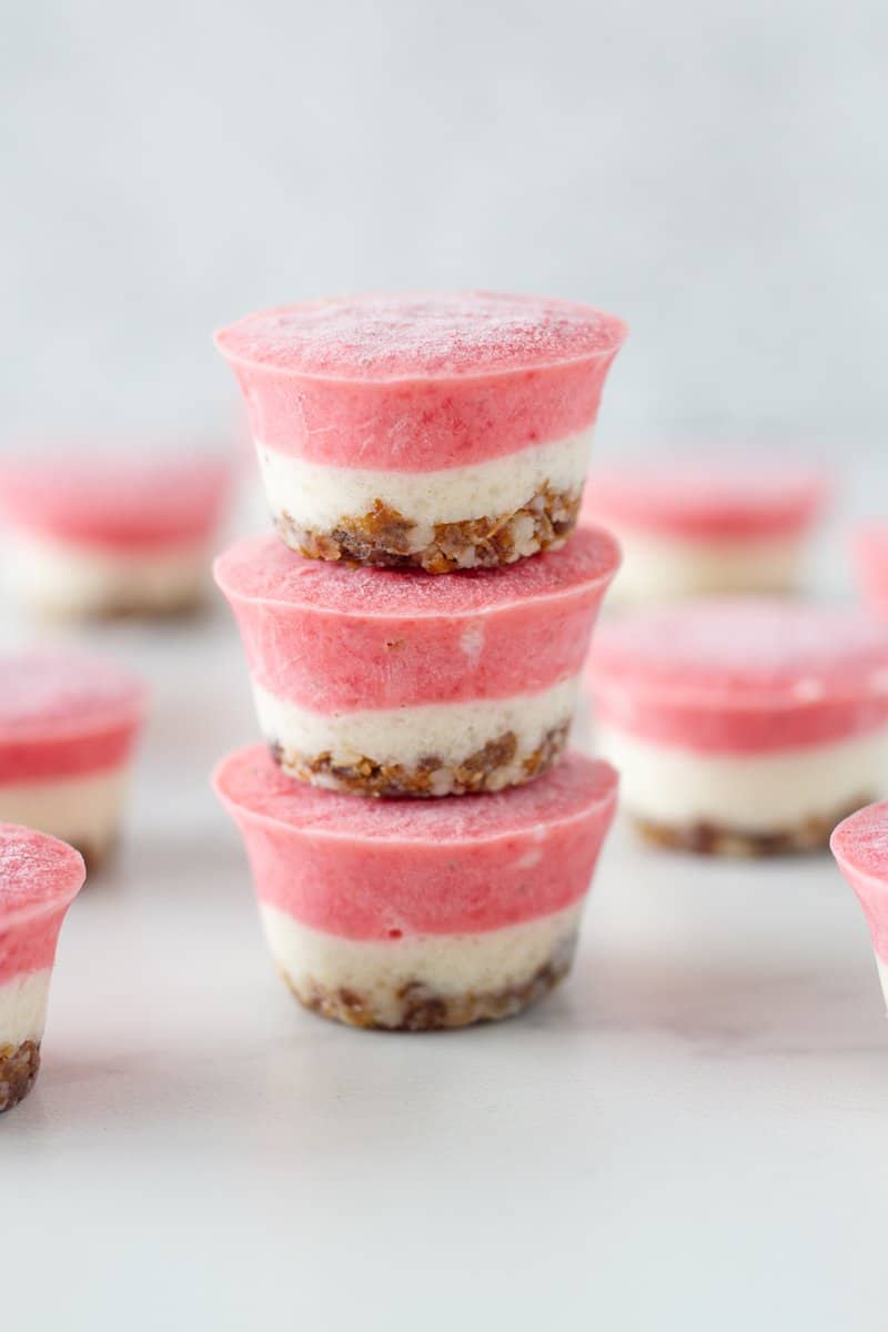 No Bake Strawberry and Lemon Cheesecake Bites! Consisting of three amazing layers, the macadamia and date base, lemon layer and the strawberry layer on top. These delicious mini raw cheesecakes are super easy to make and have the most amazing flavour. 