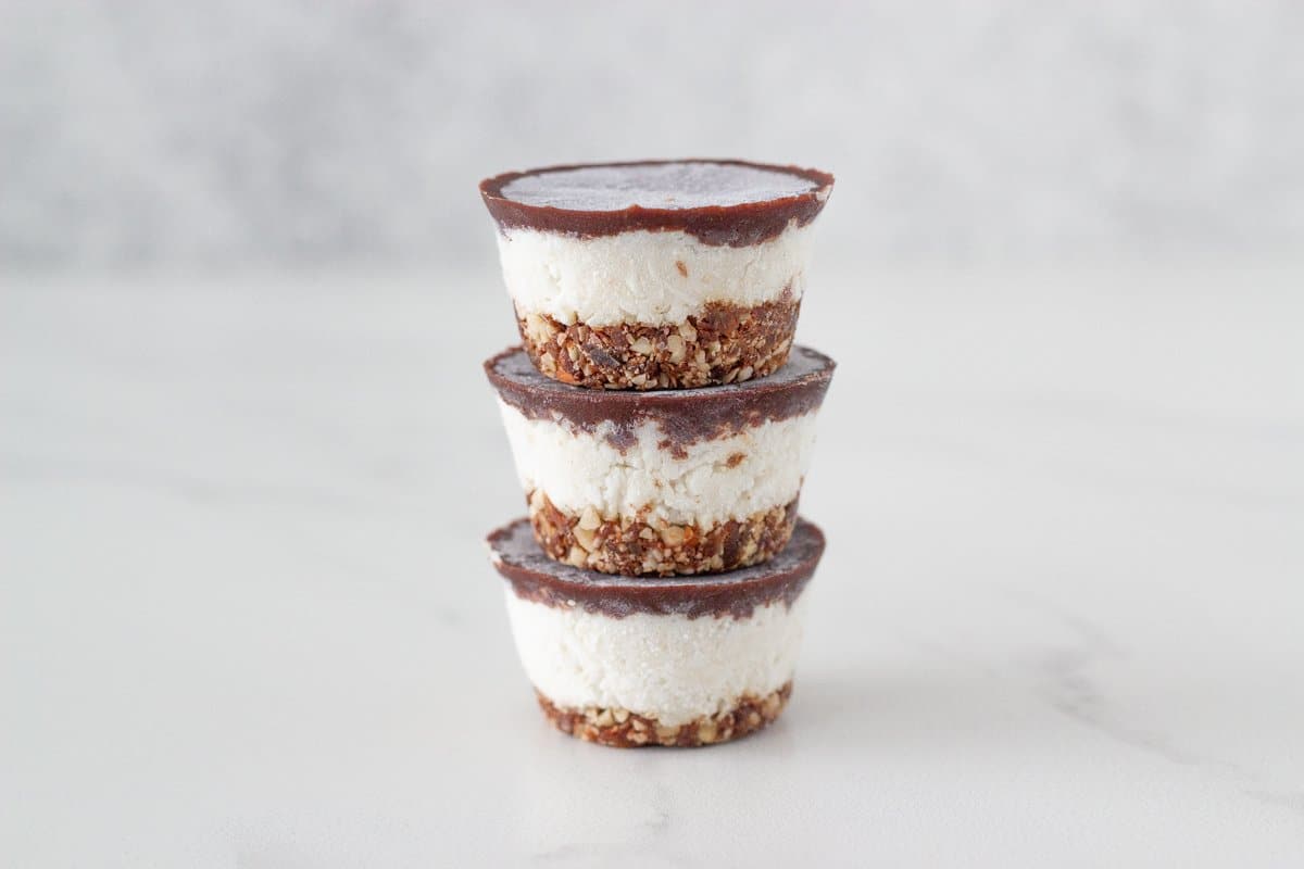 Mini Bounty Slice Bites! These delicious bite-sized raw slices are made with three layers, a chocolate nut base, bounty centre and raw chocolate layer on top.