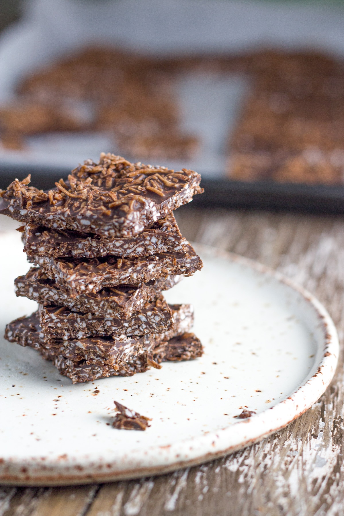 Raw chocolate pieces stacked on a plate. 