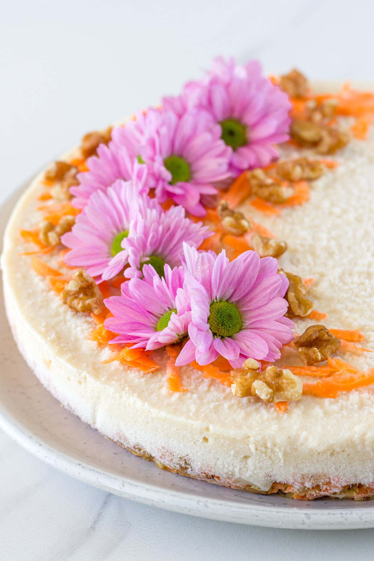 The cake decorated with flowers, carrot and walnuts.