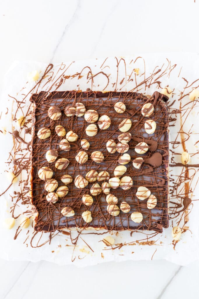 The decorated raw slice with drizzled chocolate and macadamias.