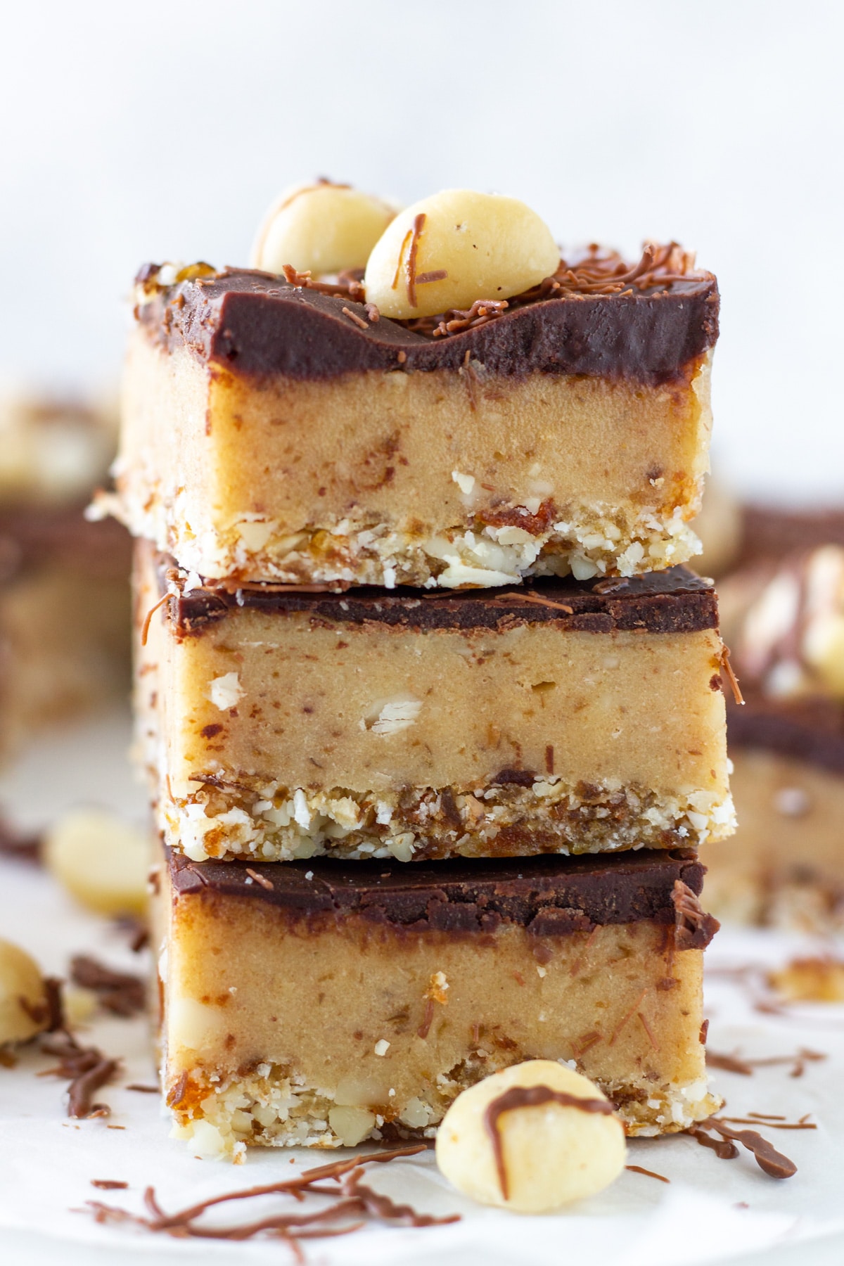 A stack of three no-bake caramel slice stacked on top of each other with the rest of the slice behind.