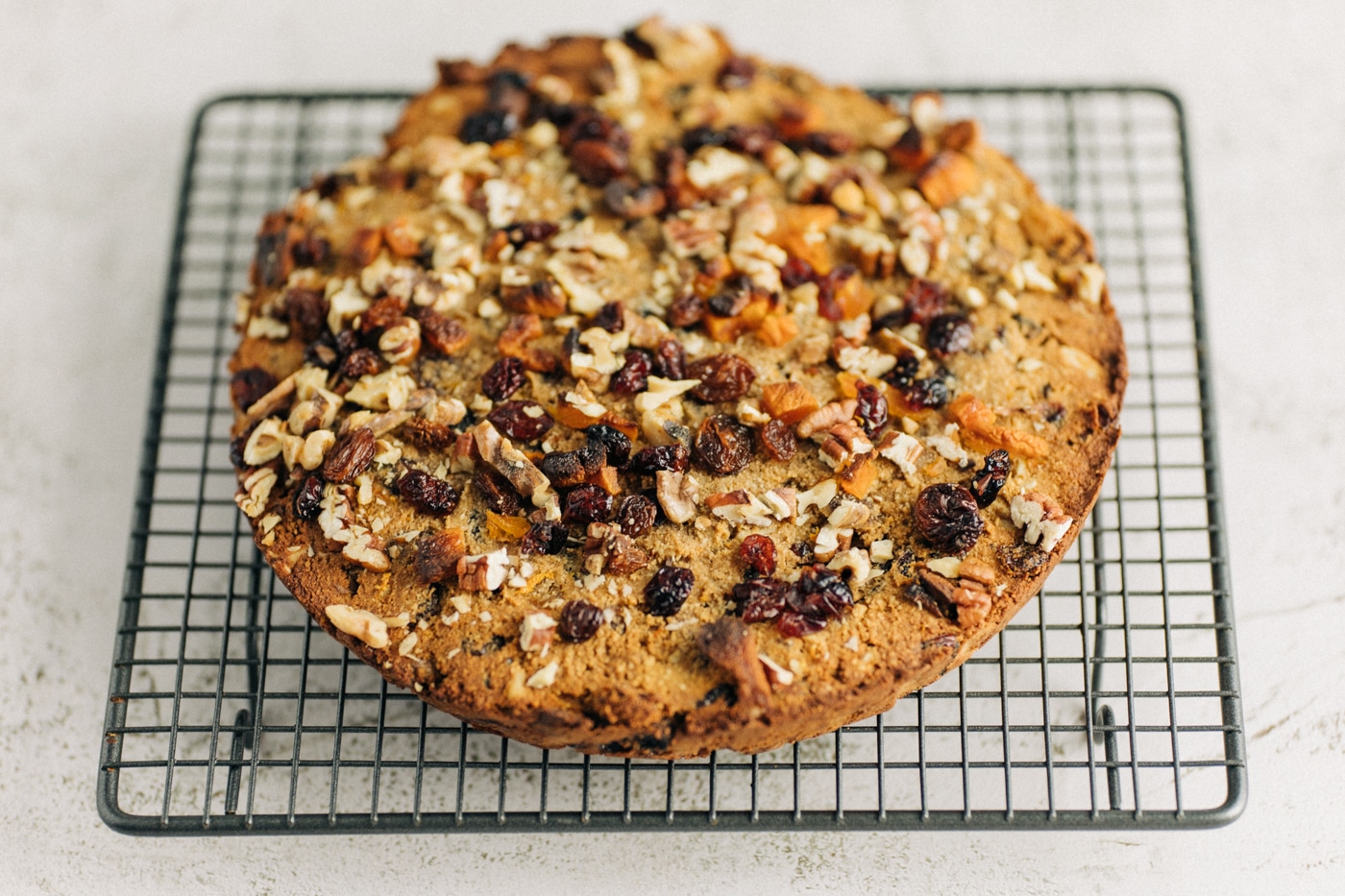 Fruit cake on a cooling rack.