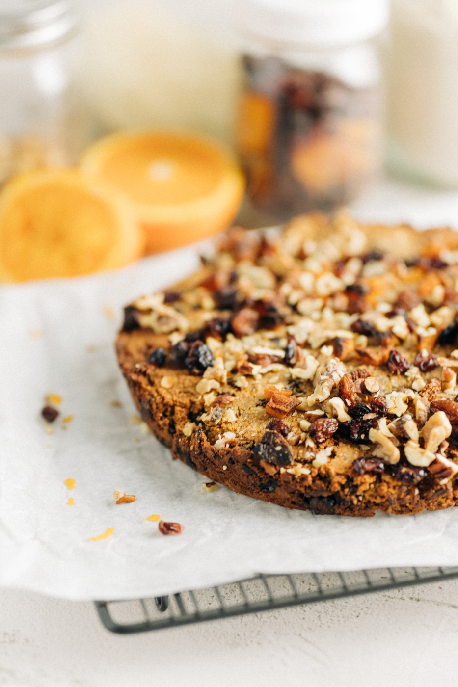 Gluten free christmas fruit cake on a cooling tray with ingredients behind it.