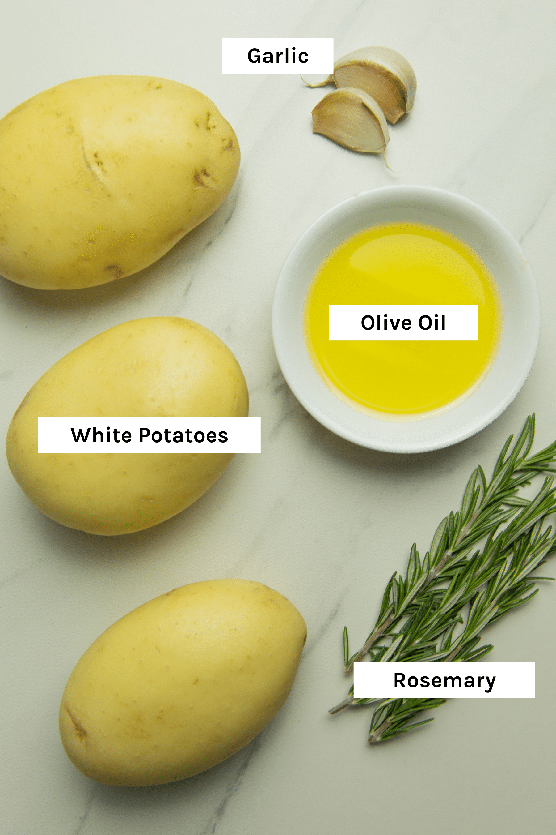 photo of the ingredients used to make these healthy oven baked fries - white potatoes, olive oil, garlic, rosemary and sea salt (which is missing from the image)