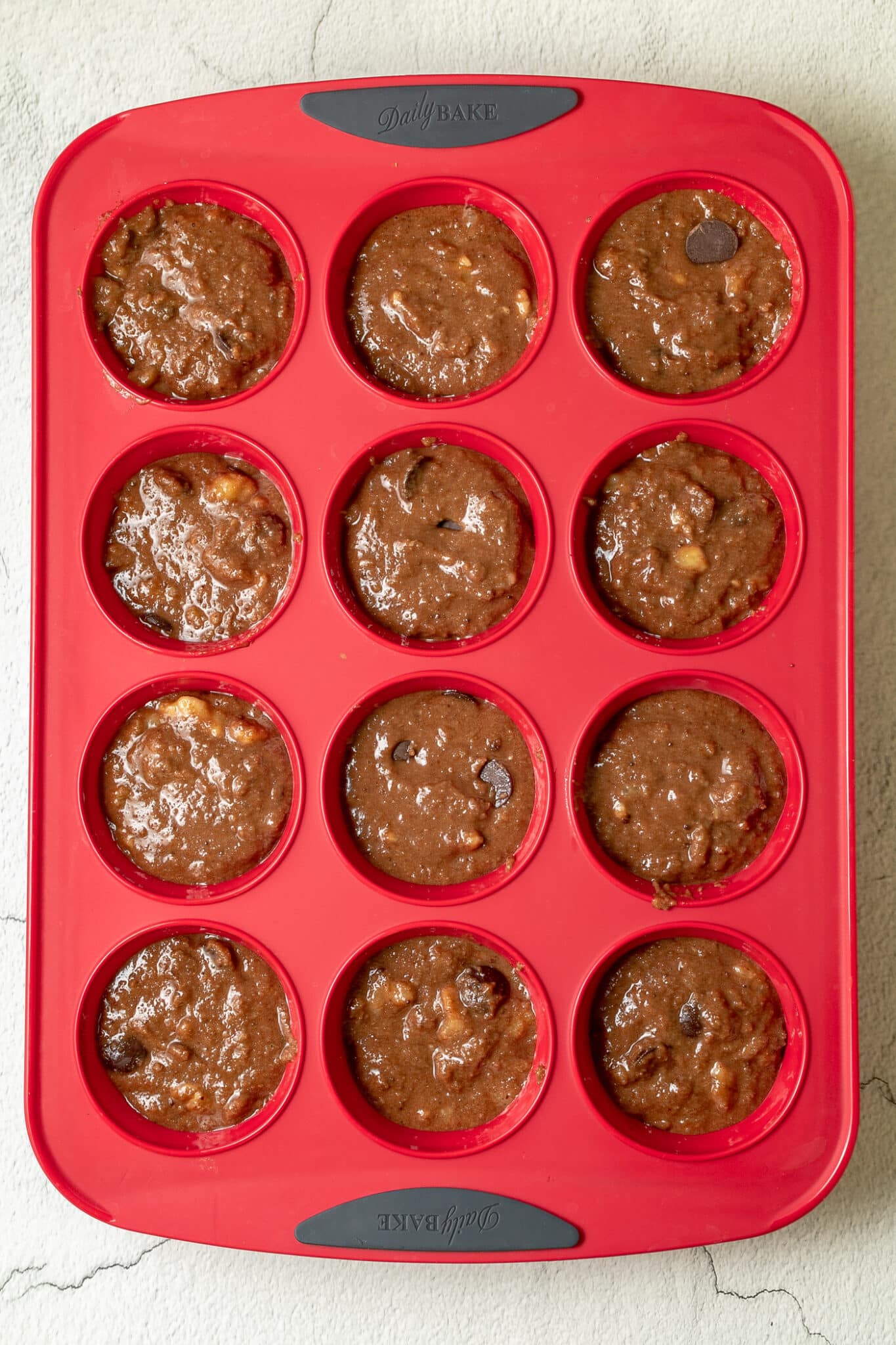 photo of silicone muffin tray with mixture added evenly among the 12 muffin sections