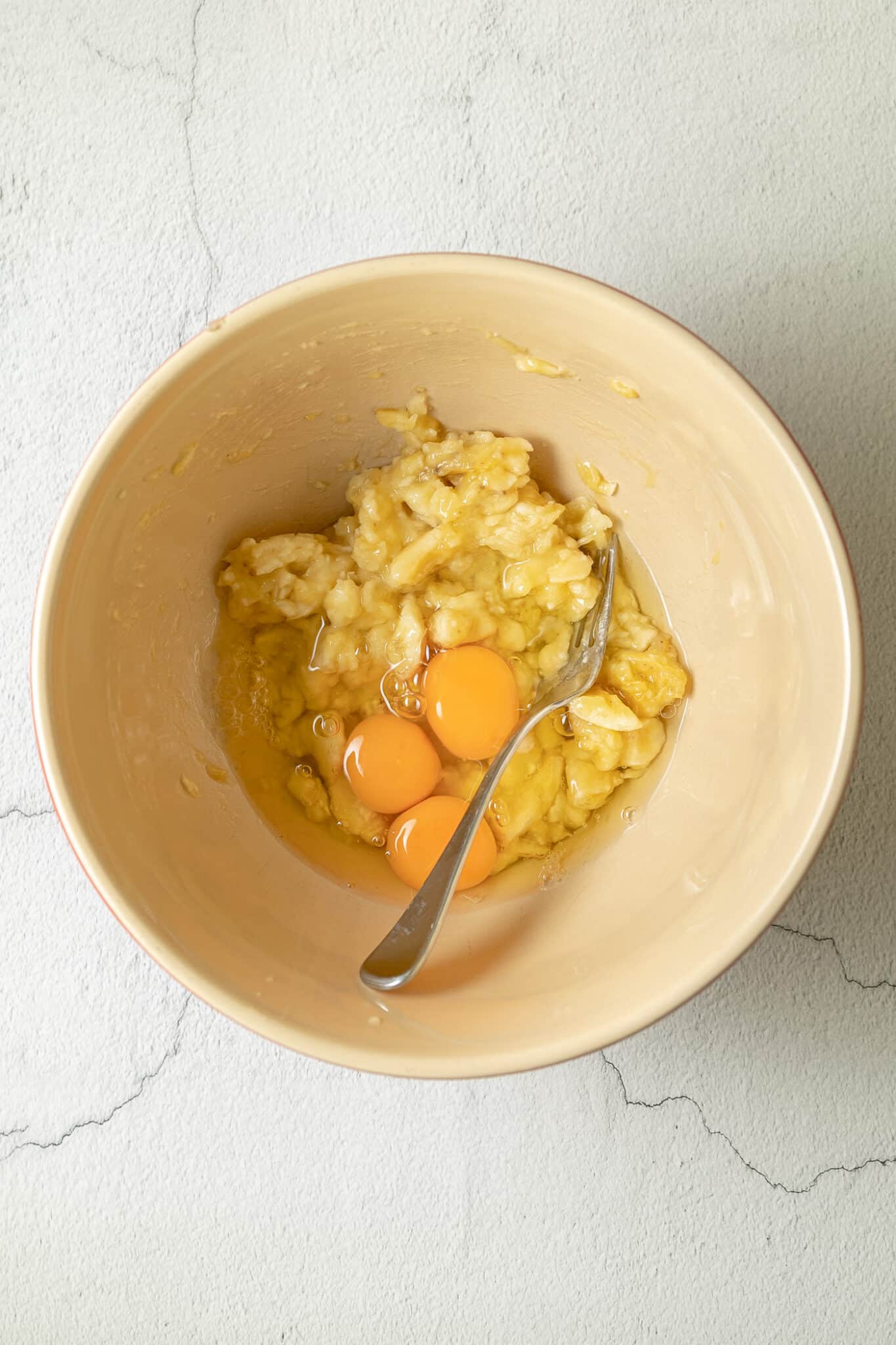 bowl with eggs and mashed bananas