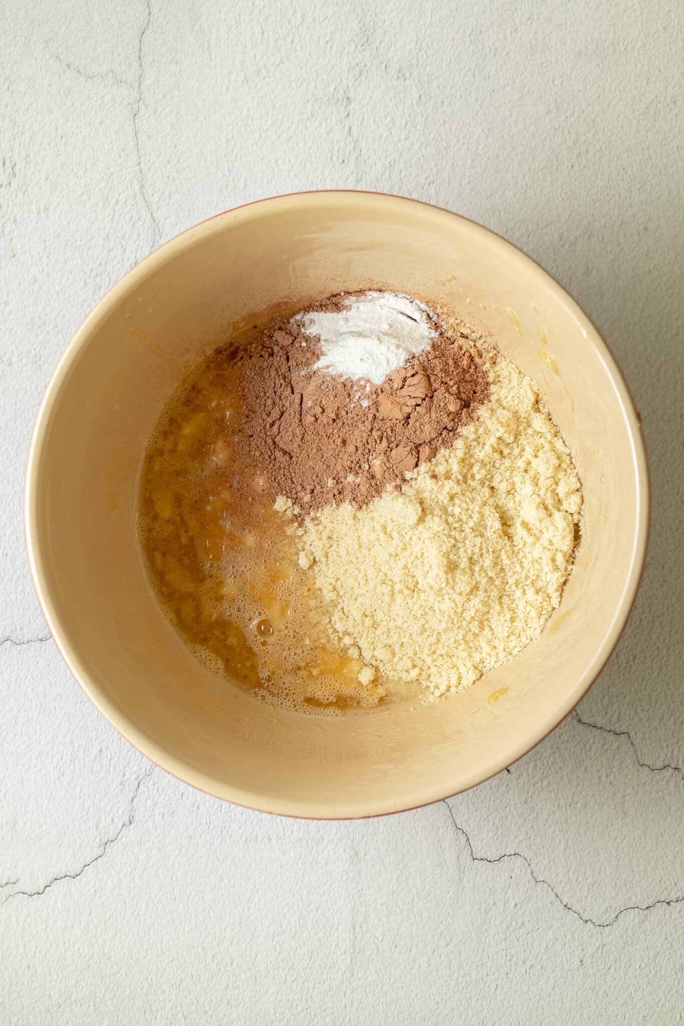 photo of almond meal, cacao powder and baking powder added to the bowl of the wet ingredients