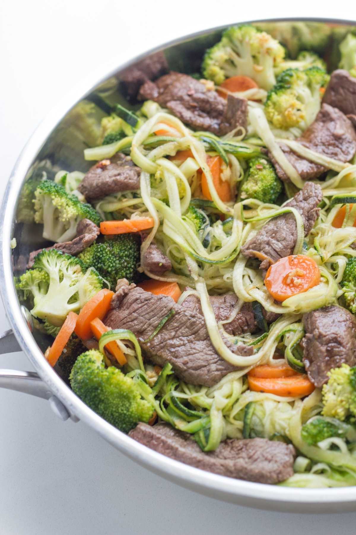 A skillet with the Zucchini Noodle Stir-Fry with Beef ready to eat.