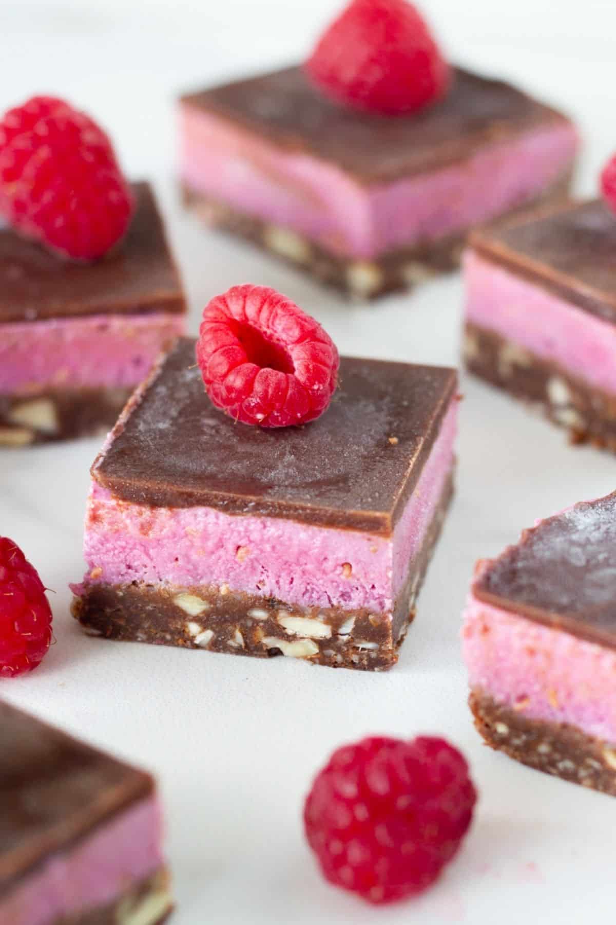 Chocolate raspberry bars on a white board.