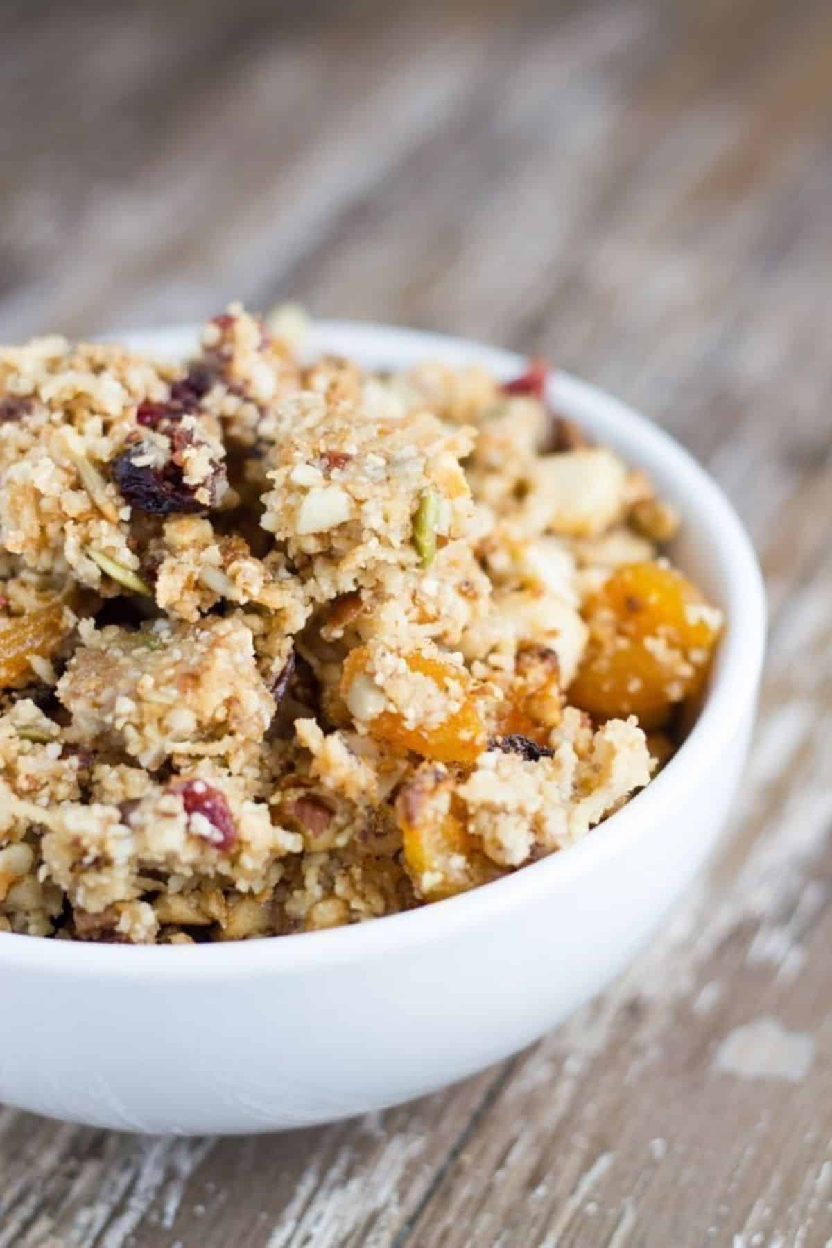 Bowl of gluten free granola on a wooden board.