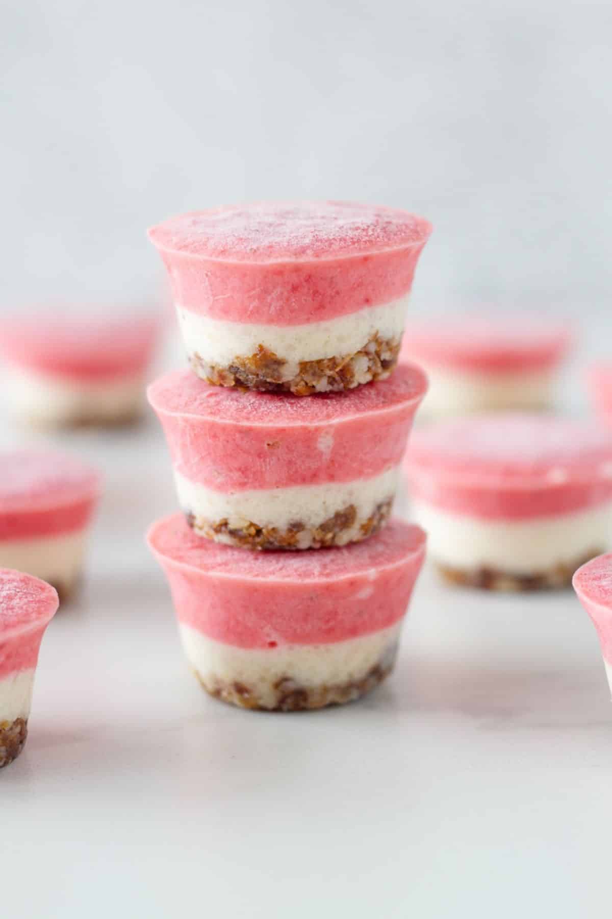 Stack of no bake cheesecake bites with more behind them.